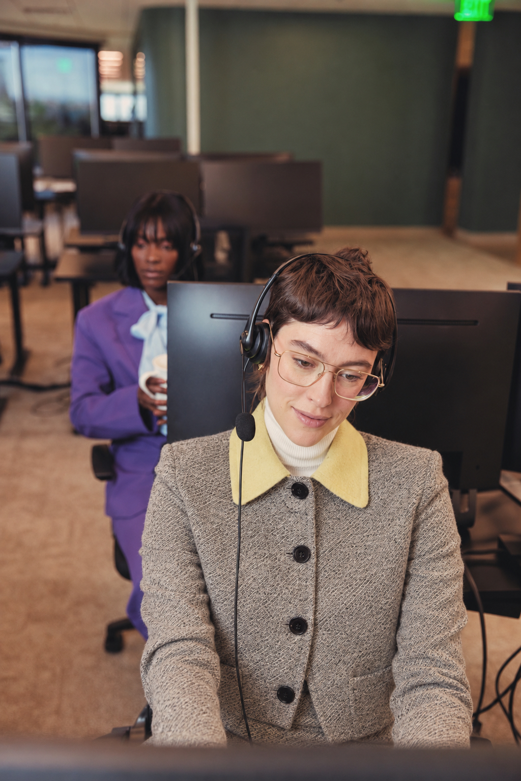 A customer support specialist holding a beige telephone